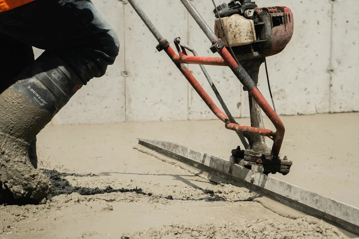 Fresh concrete slab being leveled with a power screed